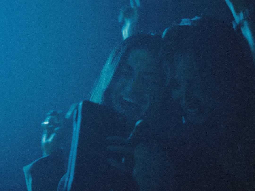 Two guests close together under blue light at Lights Out