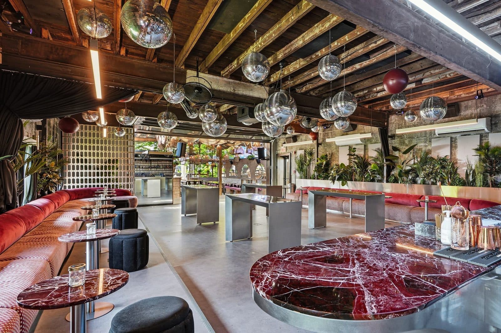 The main room at Riverside St-Henri: mirror balls hung the length of the timber ceiling above a red marble bar